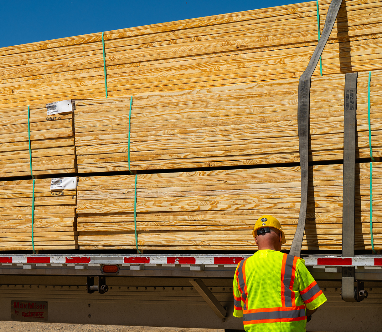 Man strapping lumber to truck